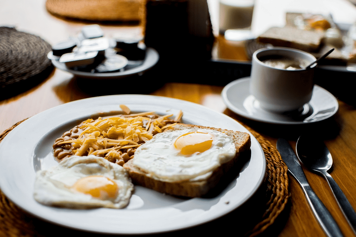 Breakfast plate with eggs, toast, beans, and coffee. Balanced diet. 
