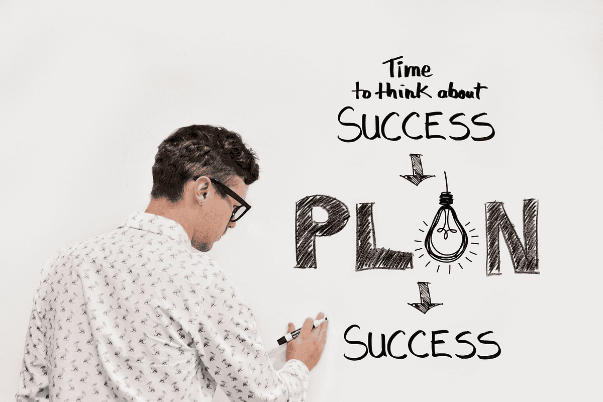 A man writing on a white board planning success. Lose 30 pounds in 30 days. 